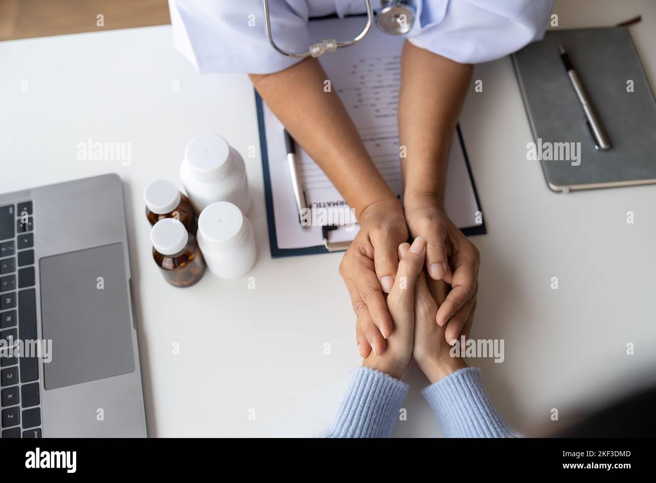 Dottore che dà speranza. Primo piano immagine di una giovane medico femminile che si appoggia in avanti a una donna anziana sorridente che tiene la mano nelle palme. Donna custode Foto Stock