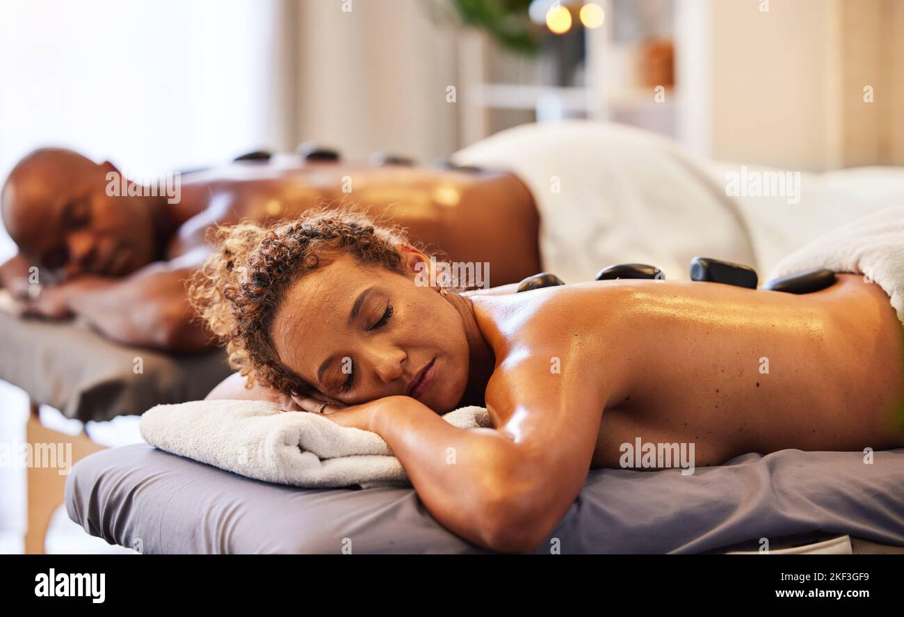 Massaggio schiena, spa in pietra e relax coppia in benessere di lusso per zen terapia, bellezza e cura della pelle. Calma, pace e persone che dormono sul lettino da salone per Foto Stock