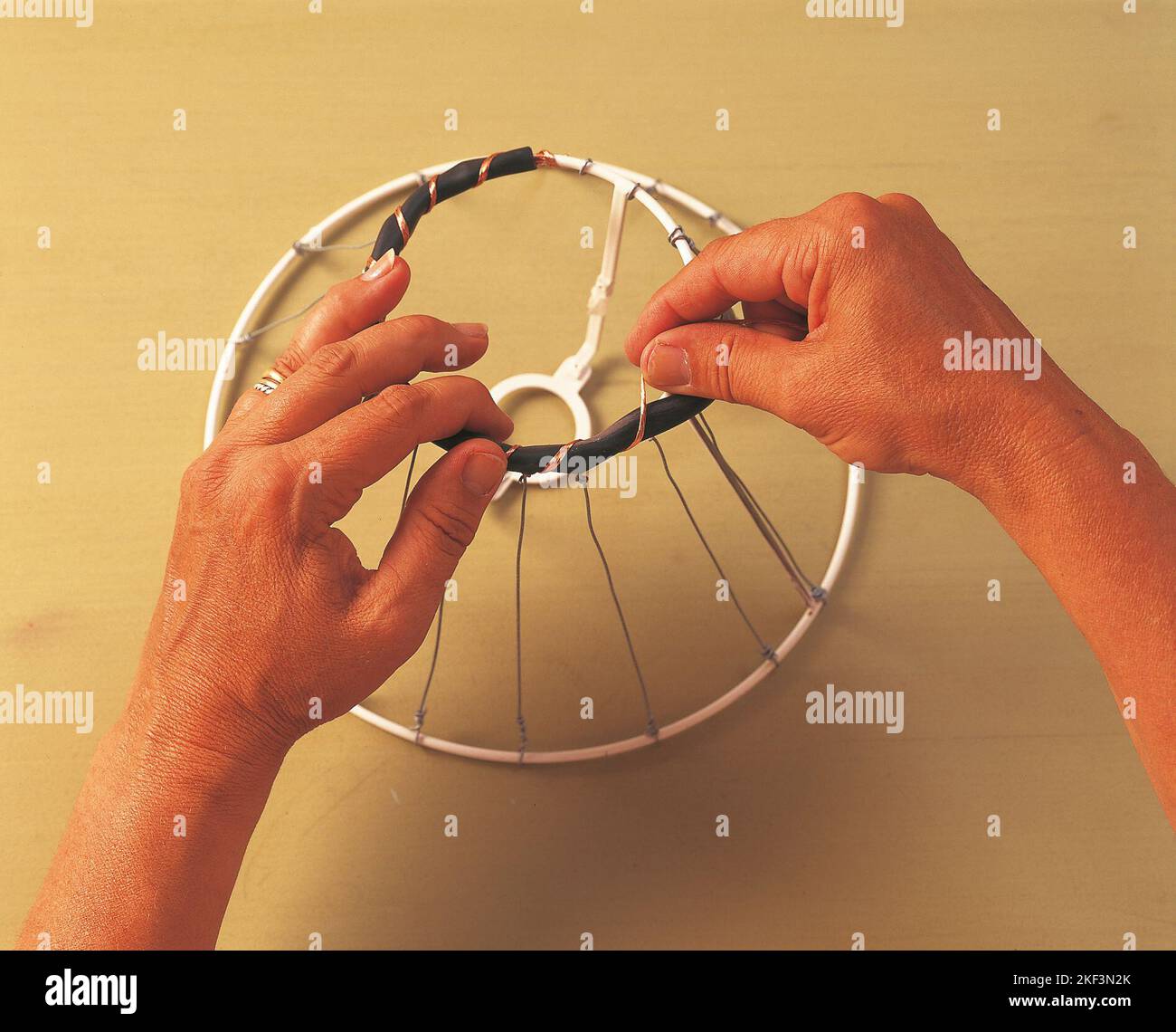Fissare un cavo nero intorno alla parte superiore del telaio con un filo di rame Foto Stock
