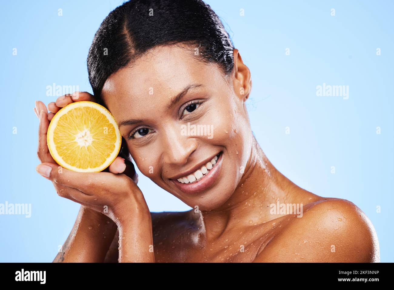 Cura della pelle, bellezza e frutta d'arancia per donna nera in studio per cosmetici, vitamina C e dermatologia benefici con gocce d'acqua sulla pelle. Verticale, volto Foto Stock