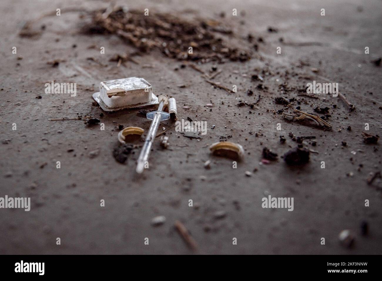 Una siringa usata viene lasciata sul pavimento del parcheggio abbandonato, e decine di siringhe, usate per introdurre sostanze nel corpo, cuciscono i primi 3 piani del parcheggio dell'aeroporto abbandonato al Terminal 2 dell'aeroporto El Prat di Barcellona. Il parcheggio a 6 piani situato nel Terminal 2 dell'aeroporto è stato abbandonato per più di 3 anni a causa dell'alto costo del parcheggio. E 'diventato casa di diverse persone senza casa al riparo dalle temperature fredde, ma è anche diventato un noto rifiuti per molti. Foto Stock