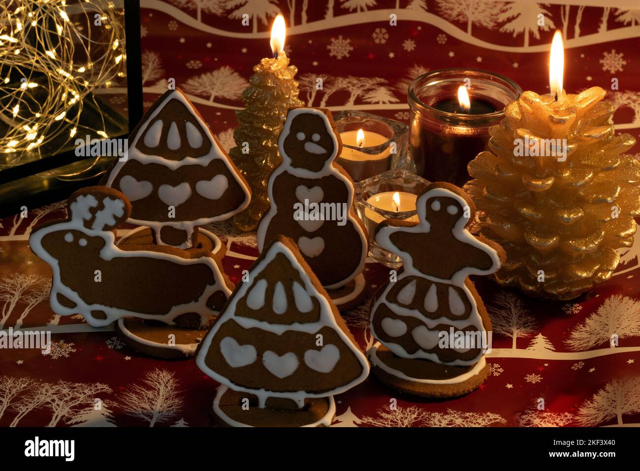 Foto pan di zenzero di Natale e candele sullo sfondo con uno sfondo rosso Foto Stock