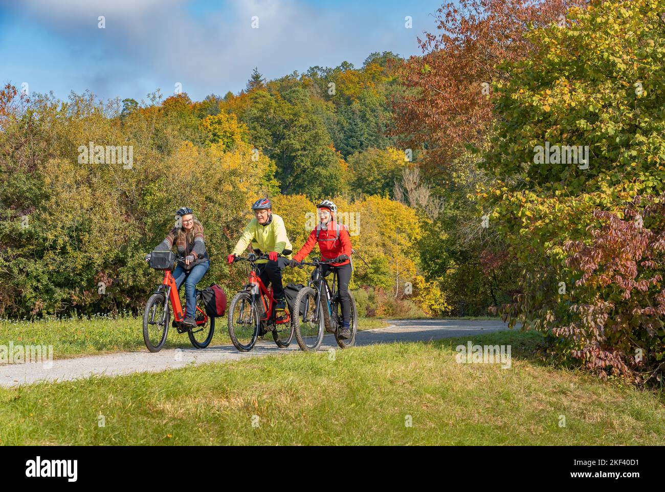Tre adulti anziani felici, in mountain bike nell'atmosfera autunnale delle foreste cadute intorno alla città di Stoccarda, Baden Wuerttemberg, GE Foto Stock