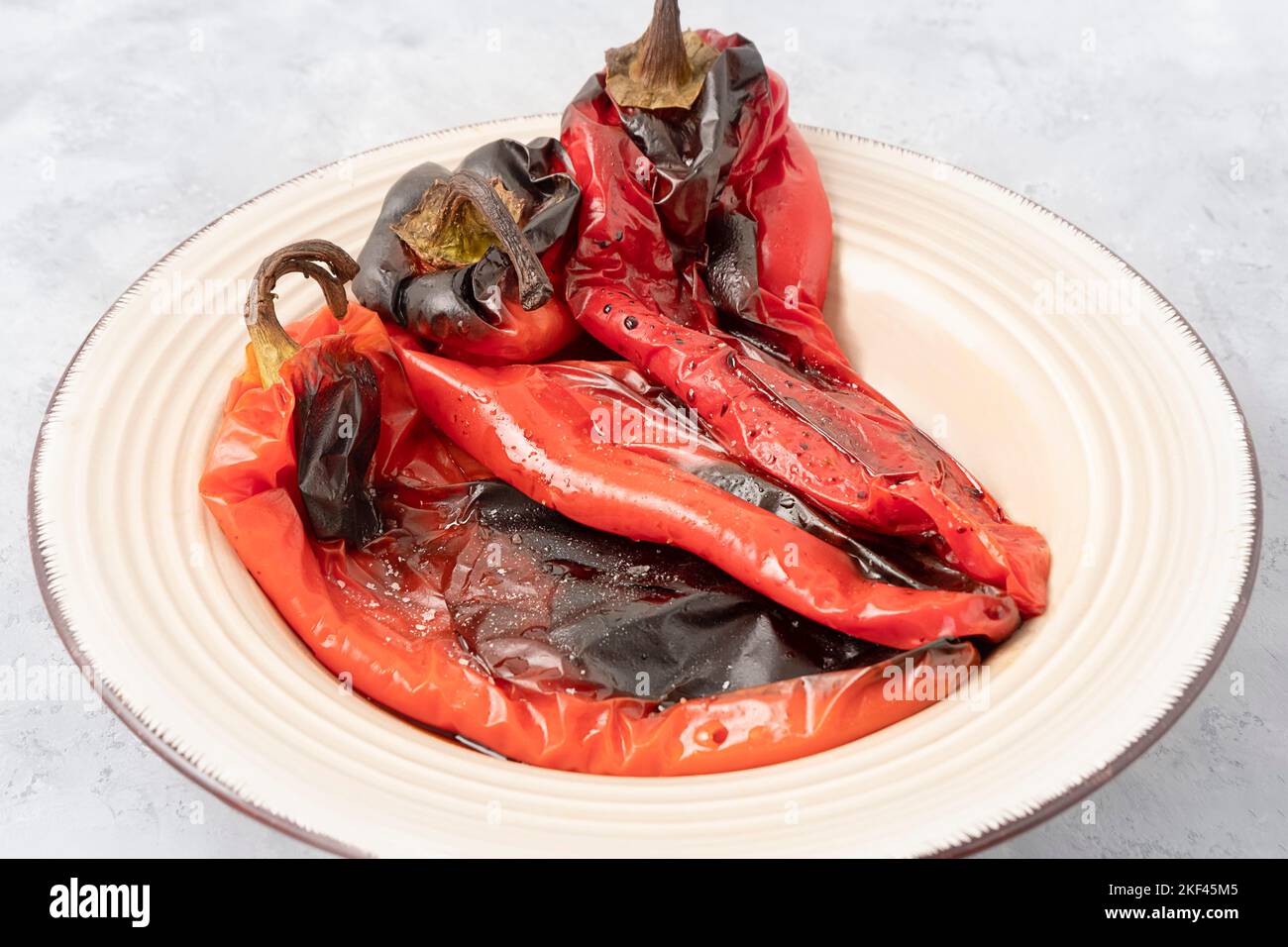 Immagine ravvicinata dei peperoni rossi arrostiti su sfondo grigio neutro. Cibo balcanico Foto Stock