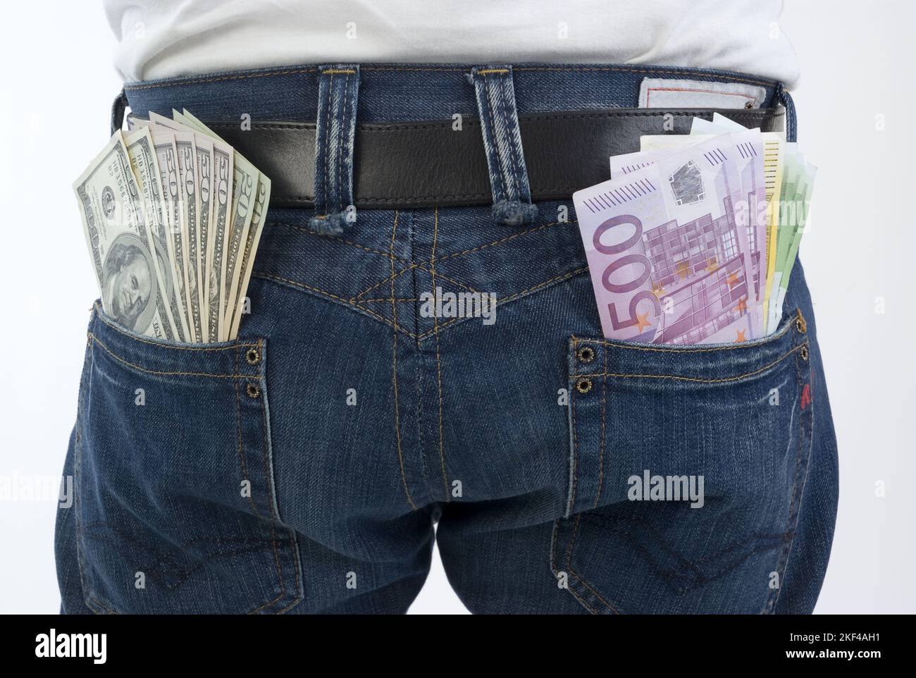 Ein Man Hat mehrere Dollarscheine und Eurobanconoten in den Hosentaschen Seiner Jeans, Geldbündel, Lottogewinn, Schwarzgeld, Unterschlagung, Gewinn, lo Foto Stock