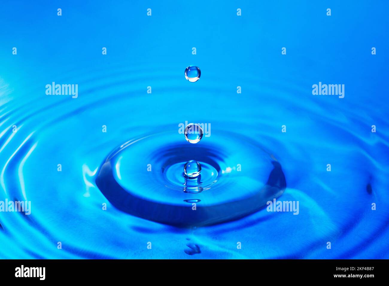 Wassertropfen caduto auf eine Wasseroberfläche Foto Stock