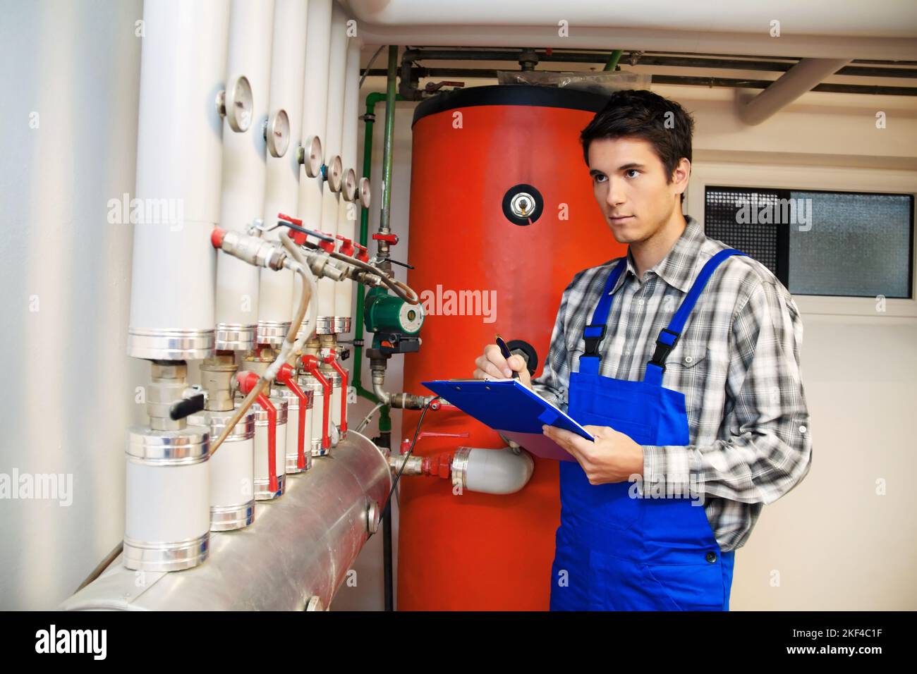 Junger Heizungstechniker überprüft eine Heizungsanlage Foto Stock