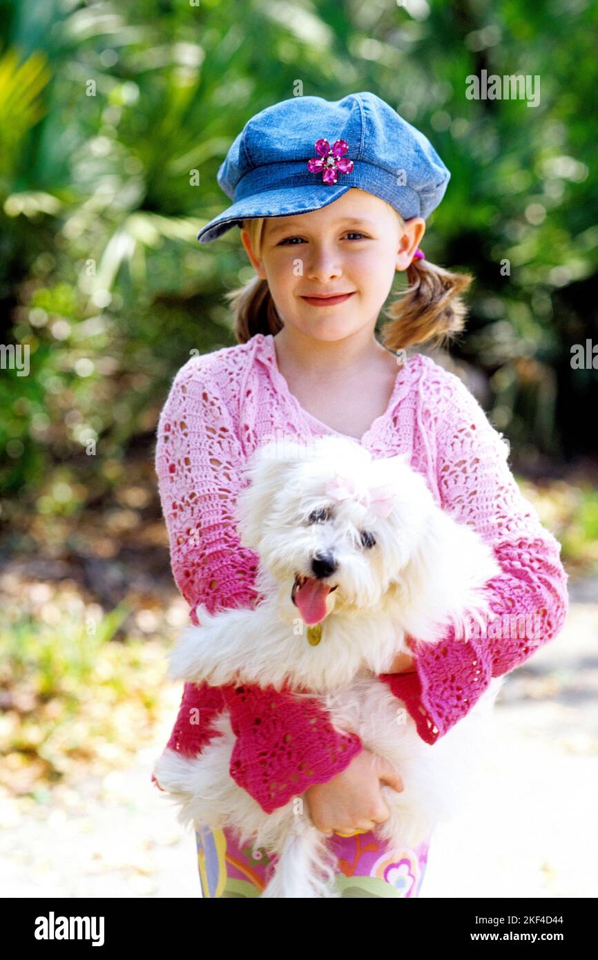 Mädchen, 5, Jahre, biondo, biondo, Blondine, hält einen Hund im Arm, kleiner Pudel, Hundebaby, Tierkinder, Freunde, Liebe, Welpe, Hundewelpe, Pudelwelp Foto Stock