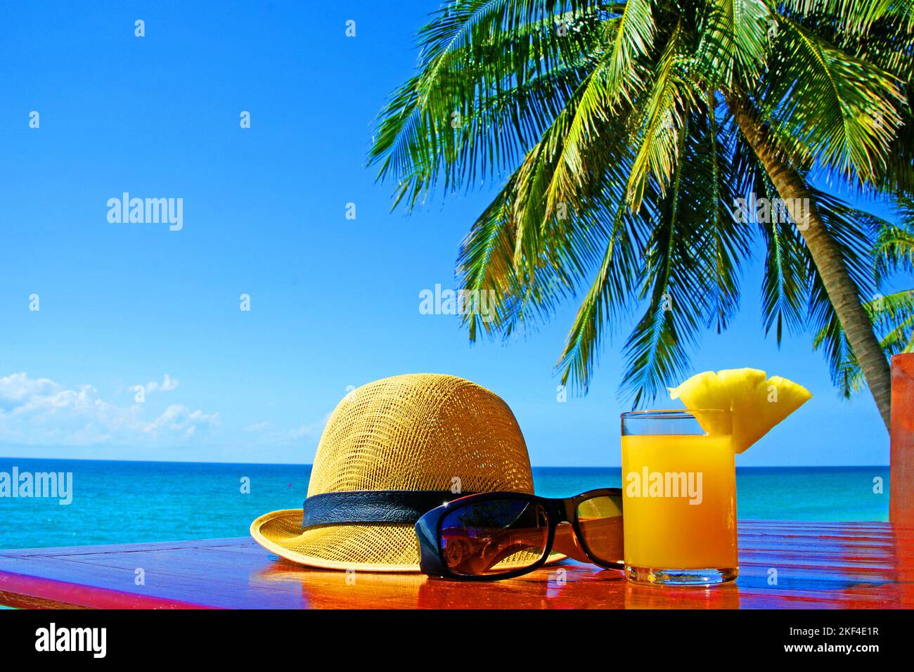 Sonnenhut mit Sonnenbrille und Fruchtsaft unter Palmen am Strand in Thailandia, Ko Samui, Koh Samui, Kho Samui, Foto Stock