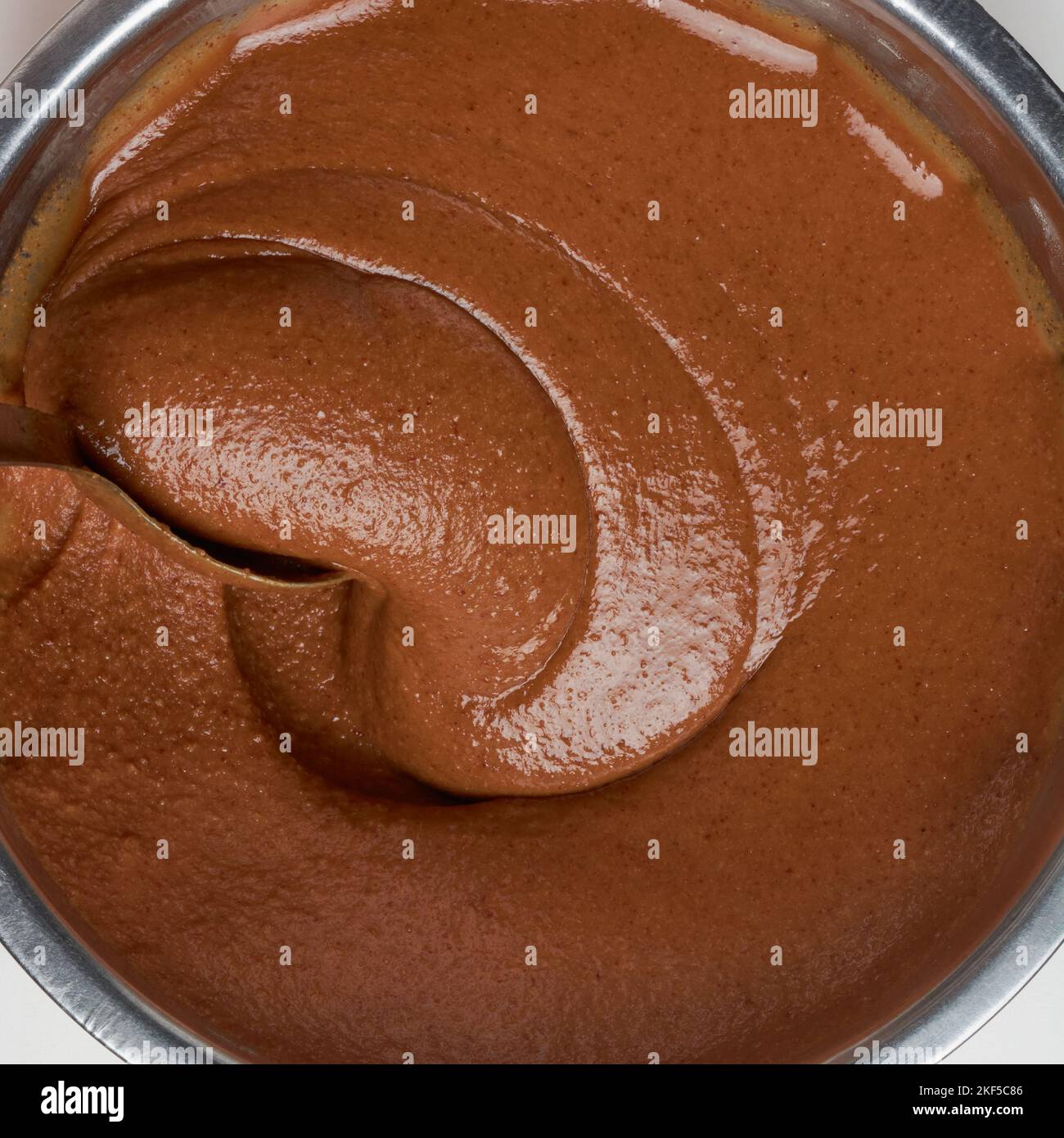 crema al caramello al cioccolato, sbattendo con un cucchiaio, composto di torta di olio closeup, preso direttamente dall'alto isolato su sfondo bianco, cibo Foto Stock