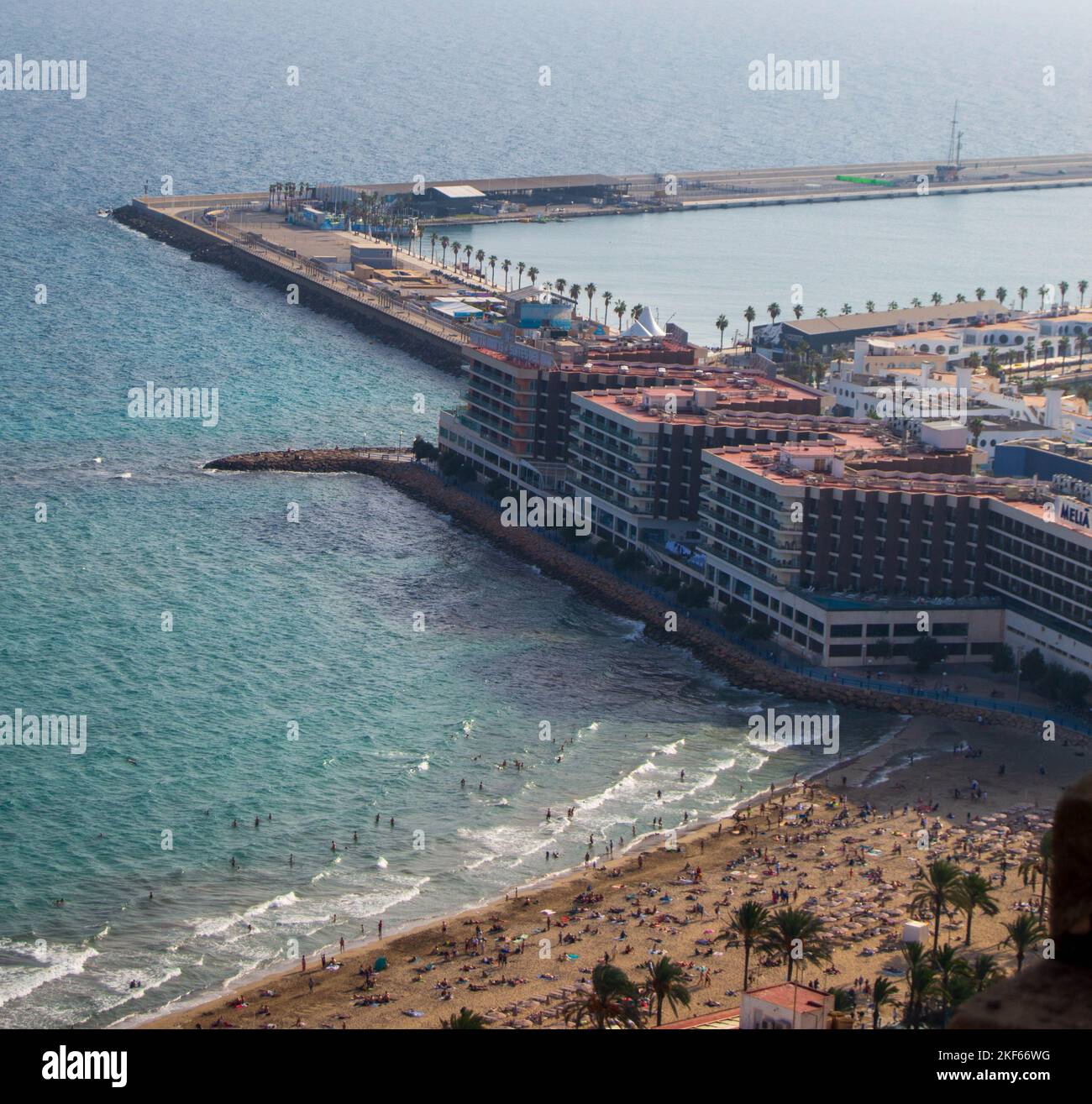 La vista aerea di persone che si divertono sulla spiaggia presso gli edifici del resort sul mare Foto Stock