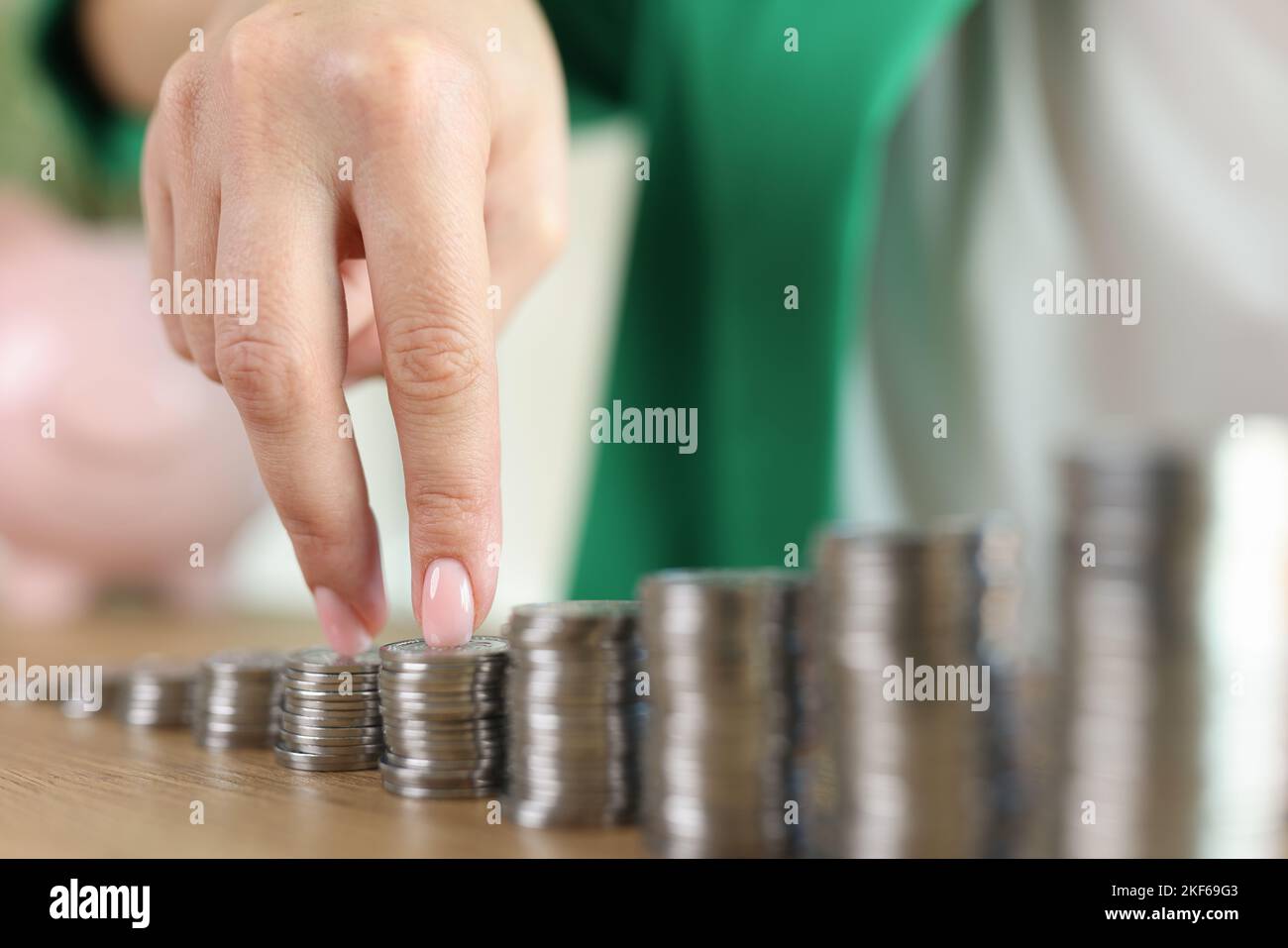 La mano si sposta su pile di monete di altezza crescente. Foto Stock