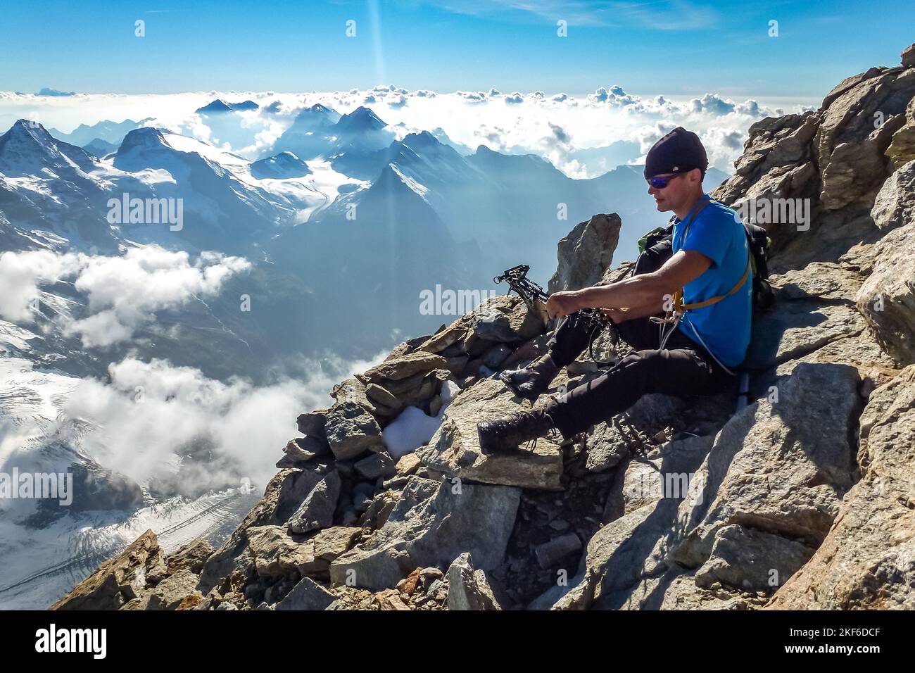 Primo piano di scarponi da montagna con ramponi e ghette da neve con raggi  solari retroilluminati e spruces nevosi sullo sfondo Foto stock - Alamy