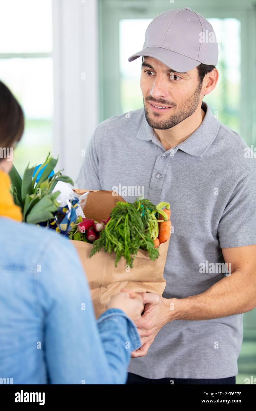 consegnare al cliente il sacchetto di cibo per la manipolazione dell'uomo Foto Stock