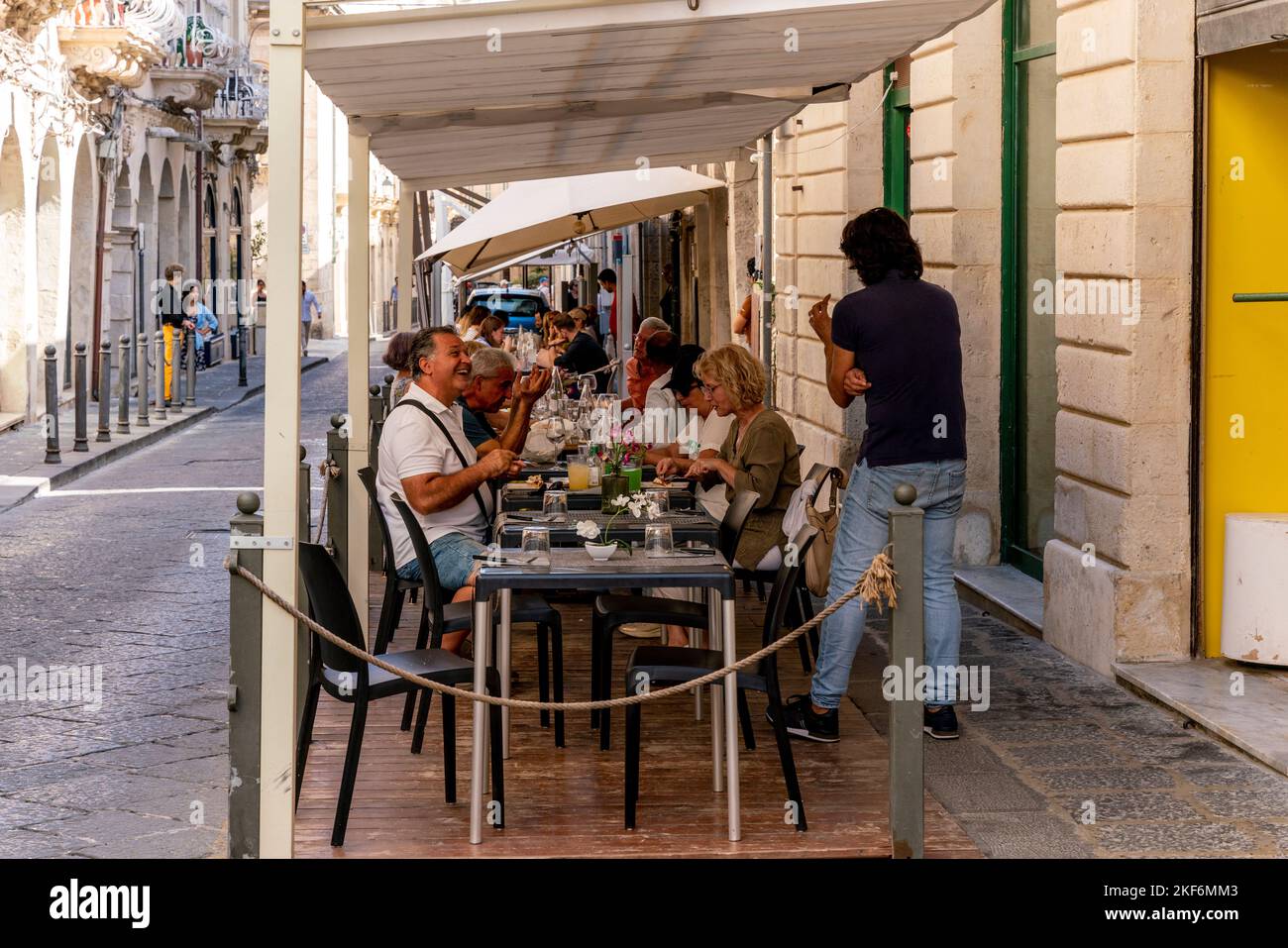I clienti seduti a pranzare fuori Da Un ristorante a Ortigia, Siracusa, Sicilia, Italia Foto Stock