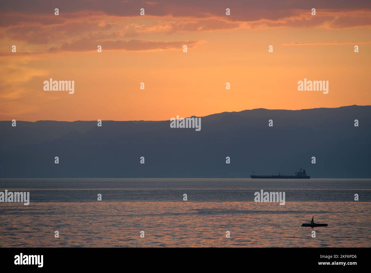 Tramonto sul Mar Rosso dal sud della Giordania. Si affaccia sul Mar Rosso fino alla penisola del Sinai in Egitto. Una piccola petroliera a metà distanza. Foto Stock