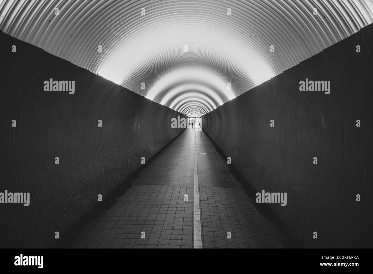 Persone nel tunnel pedonale di Brunkenberg a Stoccolma, Svezia. Immagine in bianco e nero. Foto Stock