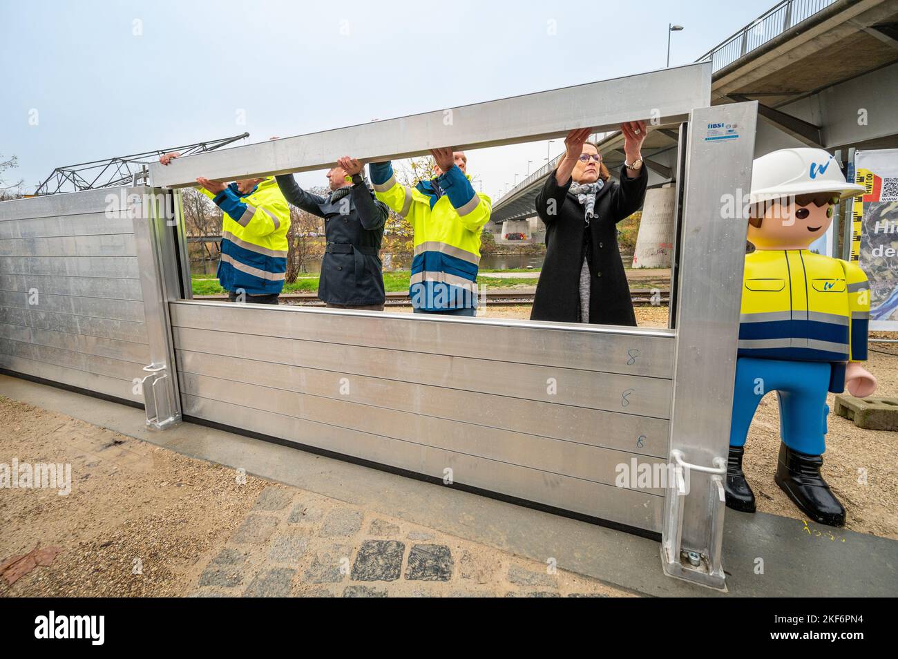 Regensburg, Germania. 16th Nov 2022. Josef Feuchtgruber (l-r), capo dell'Ufficio per la gestione delle acque di Ratisbona, Thorsten Glauber (Freie Wähler), ministro bavarese dell'ambiente, Rainer Zimmermann, responsabile del progetto per la protezione dalle inondazioni dell'Ufficio per la gestione delle acque, e Gertrud Maltz-Schwarzfischer (SPD), sindaco di Ratisbona, fissano un elemento mobile per la protezione dalle inondazioni. Dopo circa due anni e mezzo di costruzione, è stata completata l'espansione della protezione contro le alluvioni nel Westhafen di Ratisbona. Credit: Armin Weigel/dpa/Alamy Live News Foto Stock
