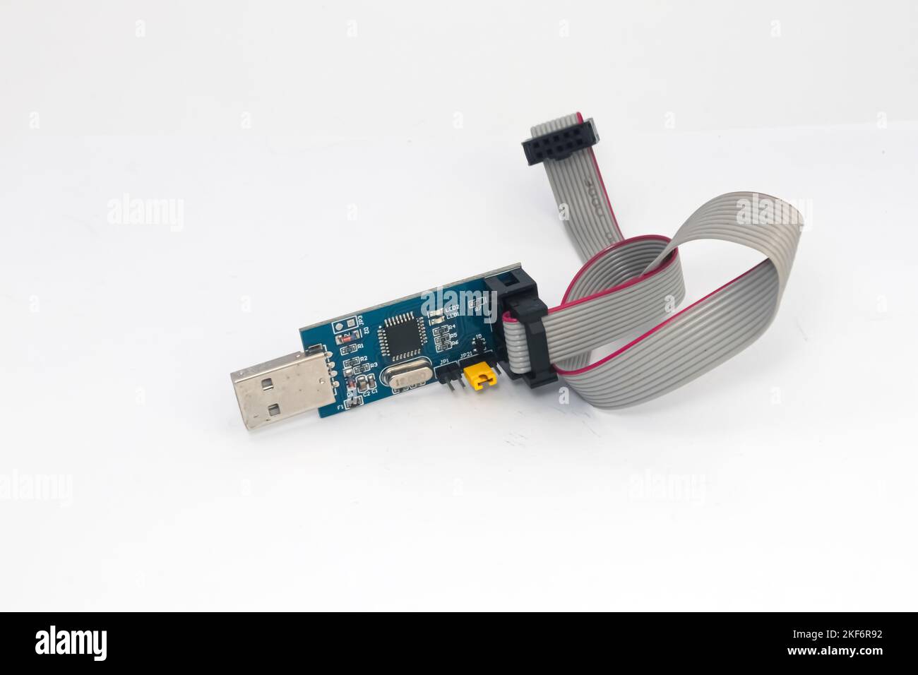 Un downloader per microcontrollori AVR con porta USB e cavo di collegamento isolato su sfondo bianco. Foto Stock