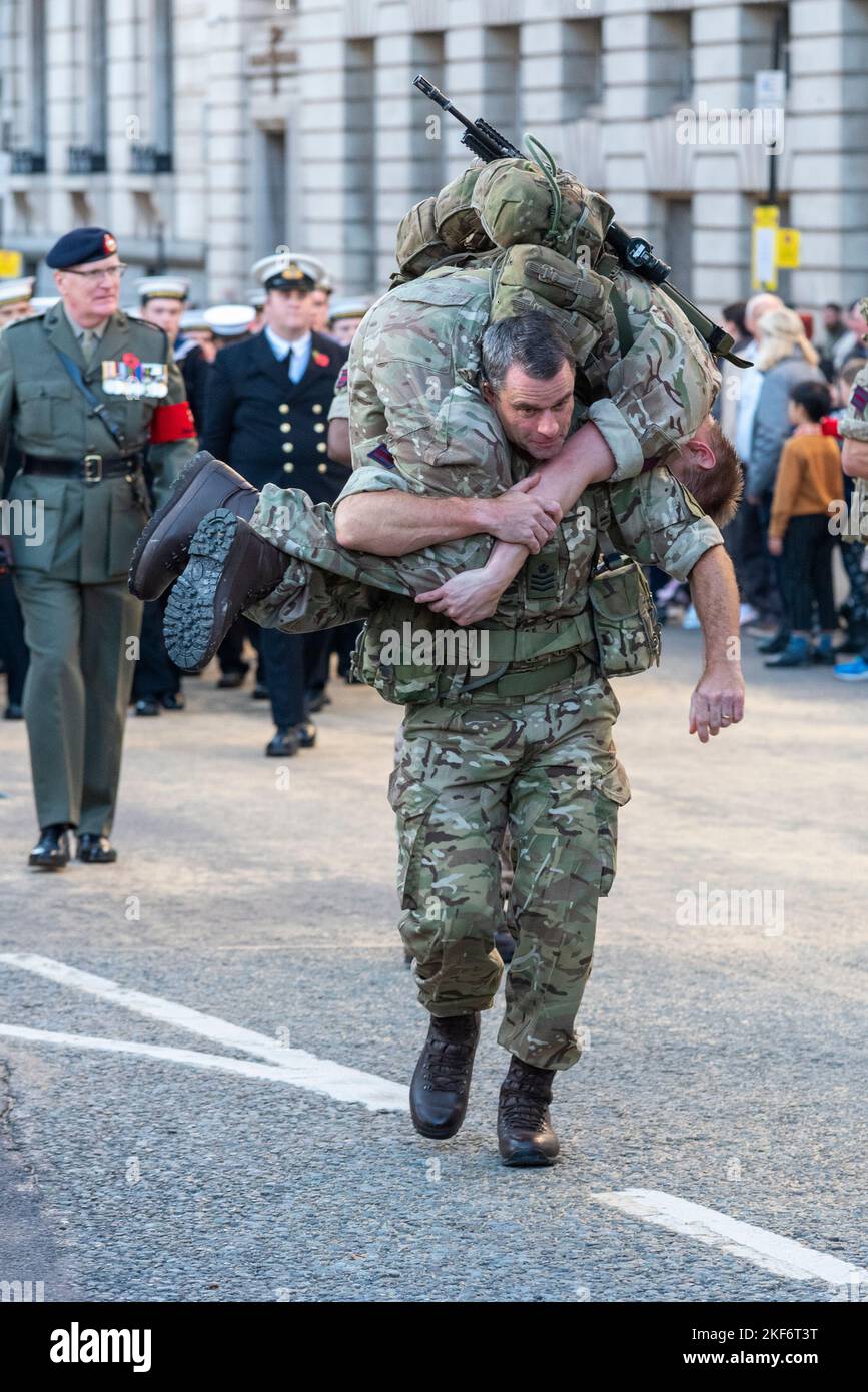 Un soldato che trasporta un altro soldato alla sfilata del Lord Mayor's Show nella City of London, Regno Unito Foto Stock