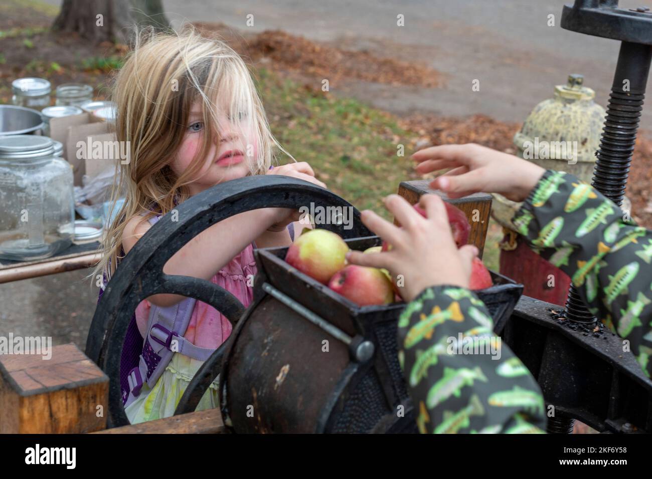 Detroit, Michigan - i bambini fanno sidro di mele con una pressa della mela ad un festival di caduta sul lato vicino orientale di Detroit. Foto Stock