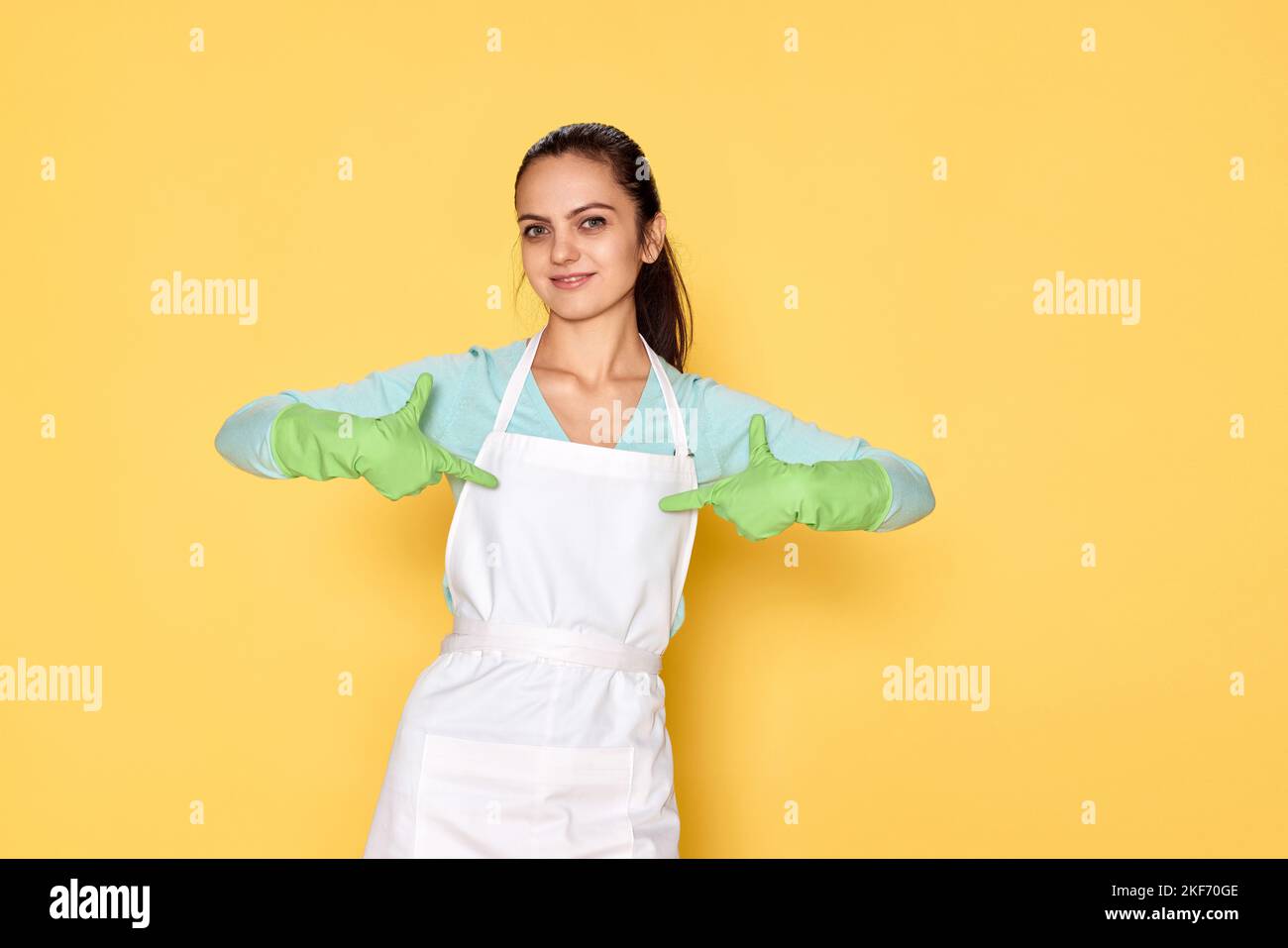 donna caucasica sorridente in guanti che si indica con le dita Foto Stock