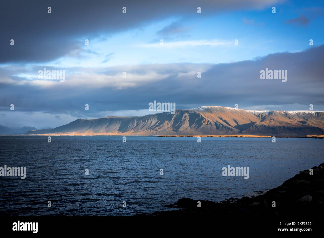 Paesaggio con il Monte Esja e la costa dell'oceano Atlantico a Reykjavik, Islanda. Non c'è gente, cielo nuvoloso blu. Foto Stock