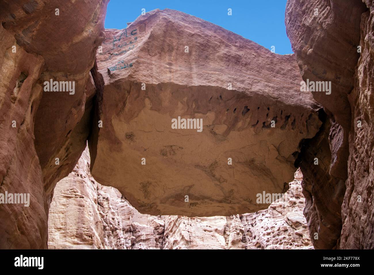 Enorme roccia sospesa tra due lati di un canyon Wadi Numeira Giordania Foto Stock