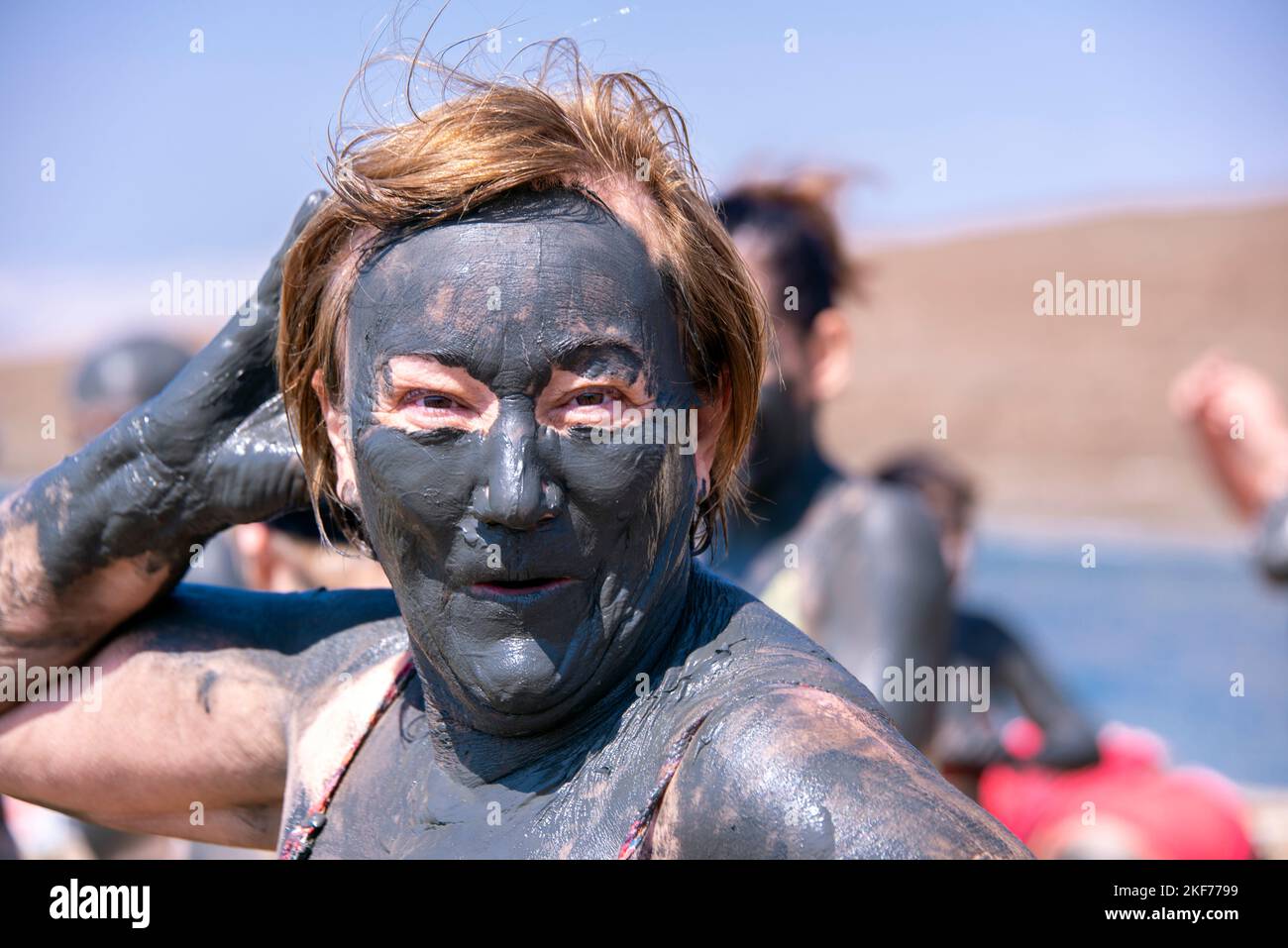 Donna coperta di fango Mar Morto Giordania Foto Stock