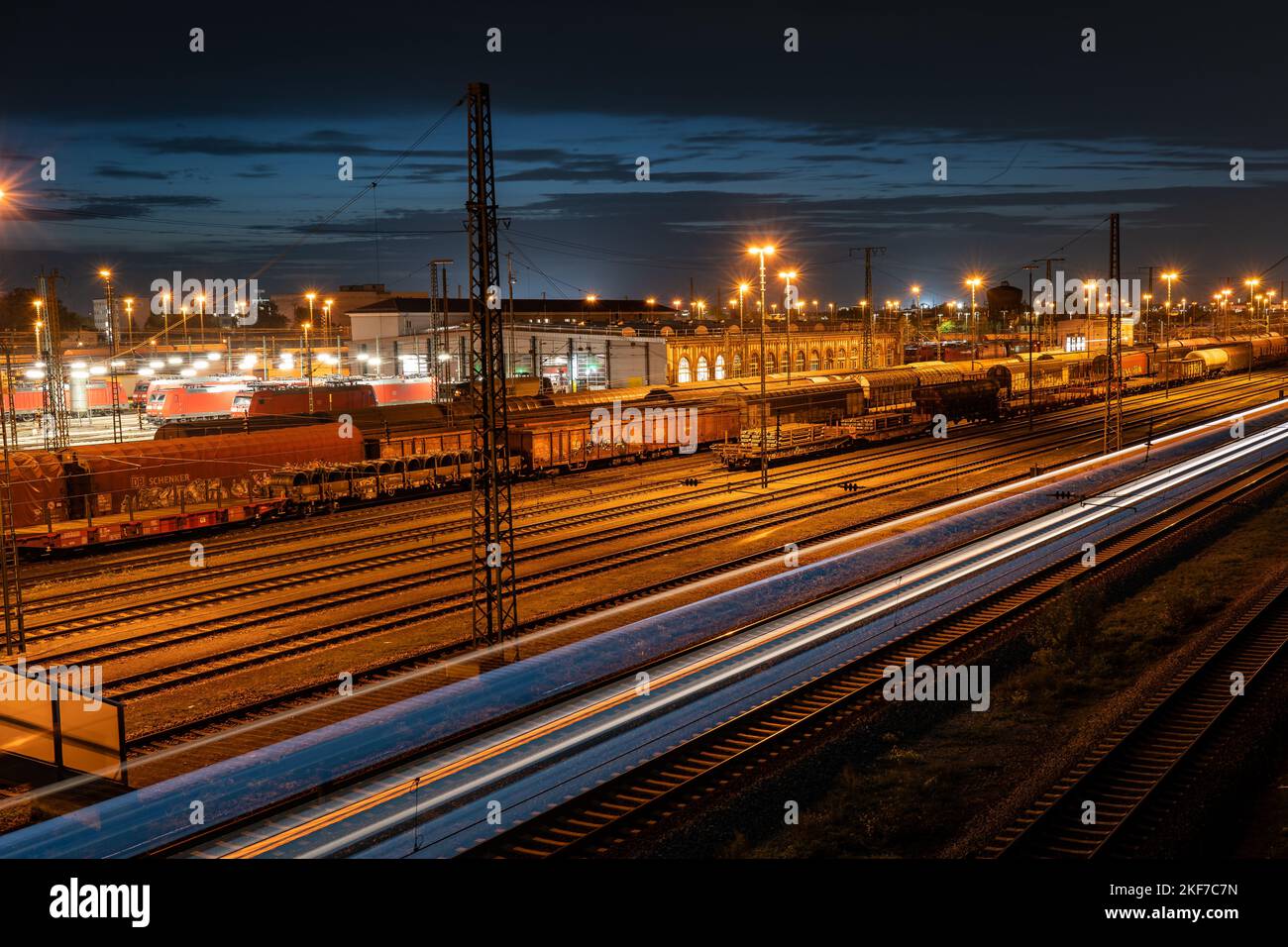 Stazione ferroviaria cargo a Mannheim di notte con treno in movimento Foto Stock