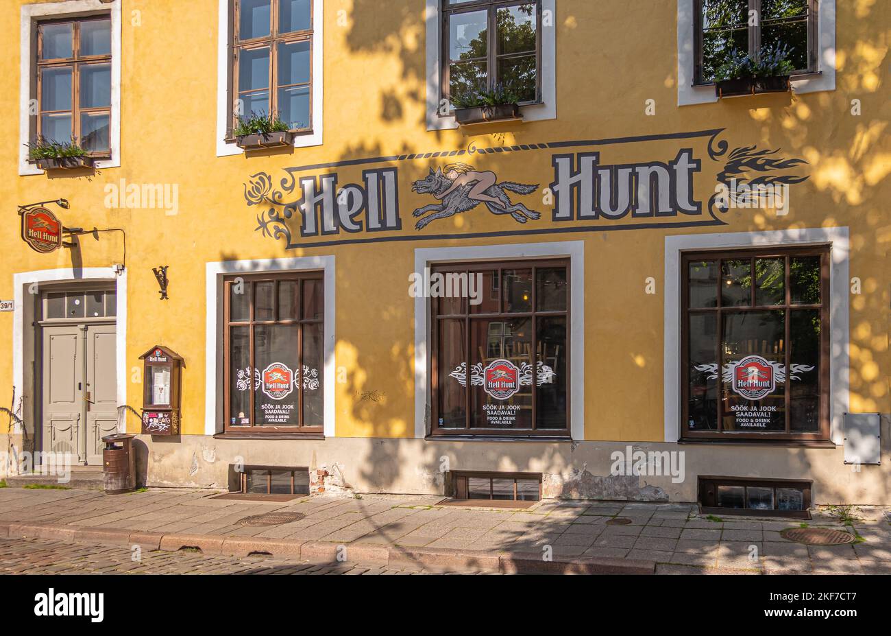 Estonia, Tallinn - 21 luglio 2022: Facciata gialla al pub Hell Hunt, bistro e ristorante con logo colorato, 3 grandi finestre e porta d'ingresso Foto Stock