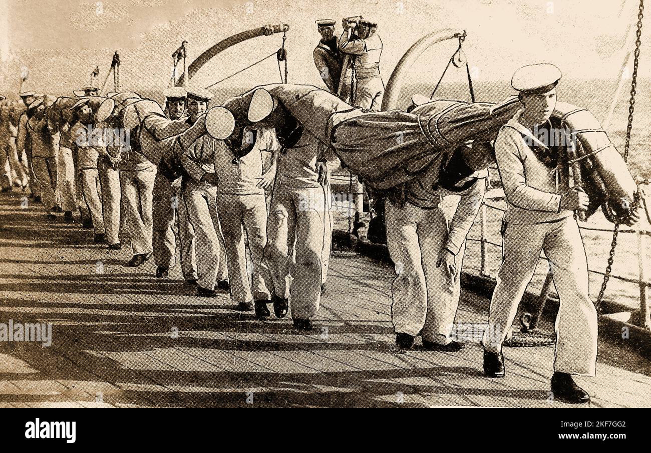 Immagine degli anni '30 di una linea di marinai britannici che trasportano una vela attraverso un ponte di legno Foto Stock