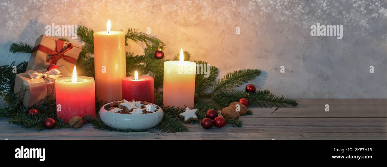 Candele di avvento in colori caldi, stelle cannella, decorazioni natalizie e rami di abete su un tavolo rustico in legno, formato panoramico, spazio copia, selezionato Foto Stock