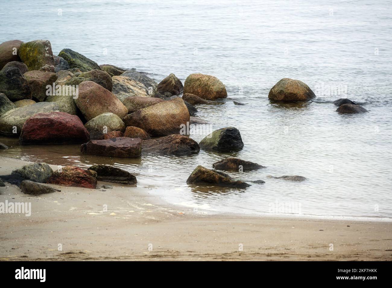 Pietre sulla spiaggia del Mar Baltico nella località turistica Lubecca Travemunde in un giorno grigio di novembre, copia spazio, fuoco selezionato, profondità stretta di fiel Foto Stock