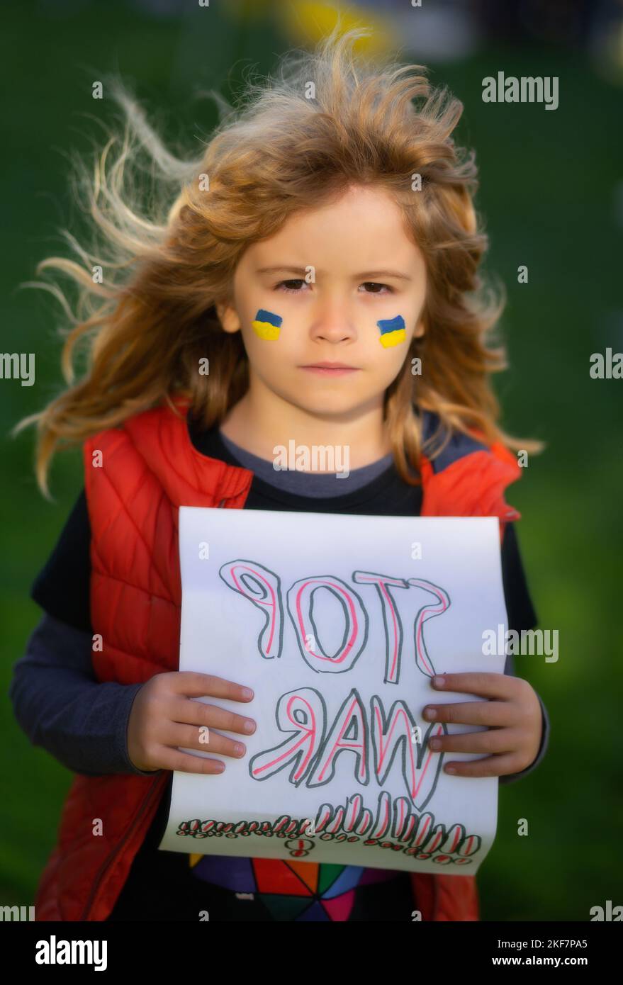 Bambino ragazzo tenendo segno con le parole Stop guerra in piedi all'aperto. Il bambino porta un cartello Stop war. Putin attacca il popolo ucraino. Foto Stock