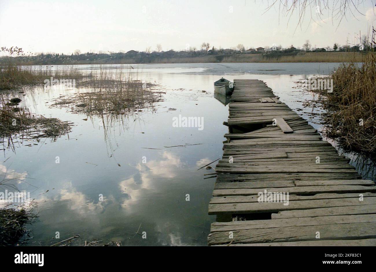 Contea di Ilfov, Romania, 1990. Barca in legno presso un vecchio molo rotto al lago Snagov. Foto Stock