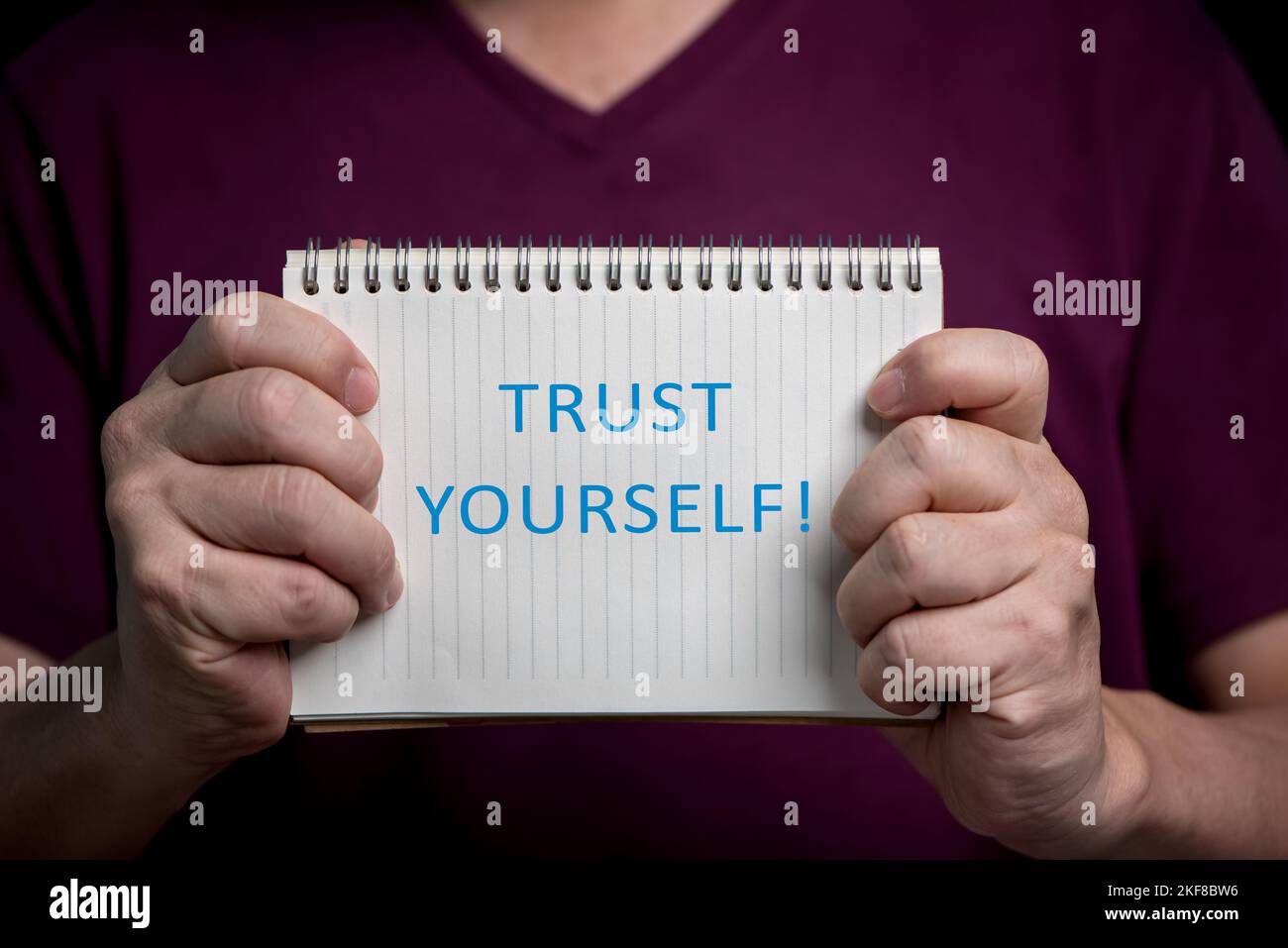 Mani dell'uomo che mostrano il notebook con la parola fidati, concetto di pensiero positivo. Foto Stock