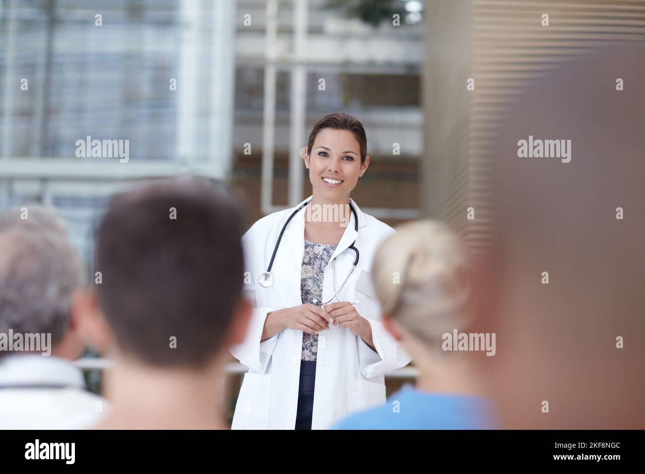 Medico che contribuisce ai suoi colleghi. Un medico che consegna un discorso davanti ad alcuni colleghi. Foto Stock