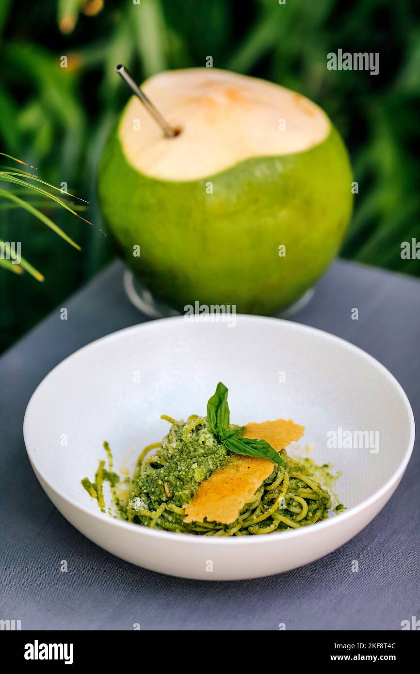 Spaghetti al pesto e al cocco sotto la foglia di palma Foto Stock