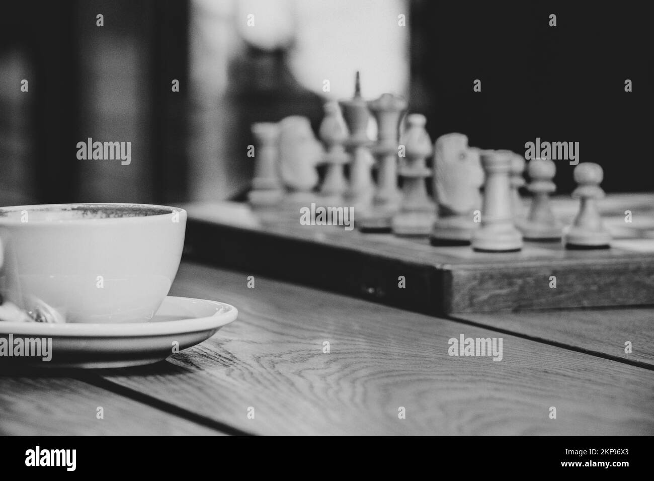 tazza di caffè vicino agli scacchi su un tavolo di legno, giocando a scacchi sopra una tazza di caffè in una pausa, pausa caffè Foto Stock