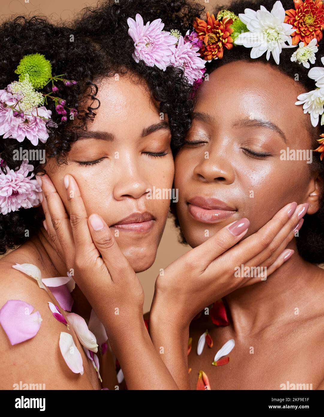 Occhi chiusi, bellezza e donne nere con fiori per la cura della pelle in studio su sfondo marrone. Cosmetici biologici, trucco estetica e gruppo, amici Foto Stock