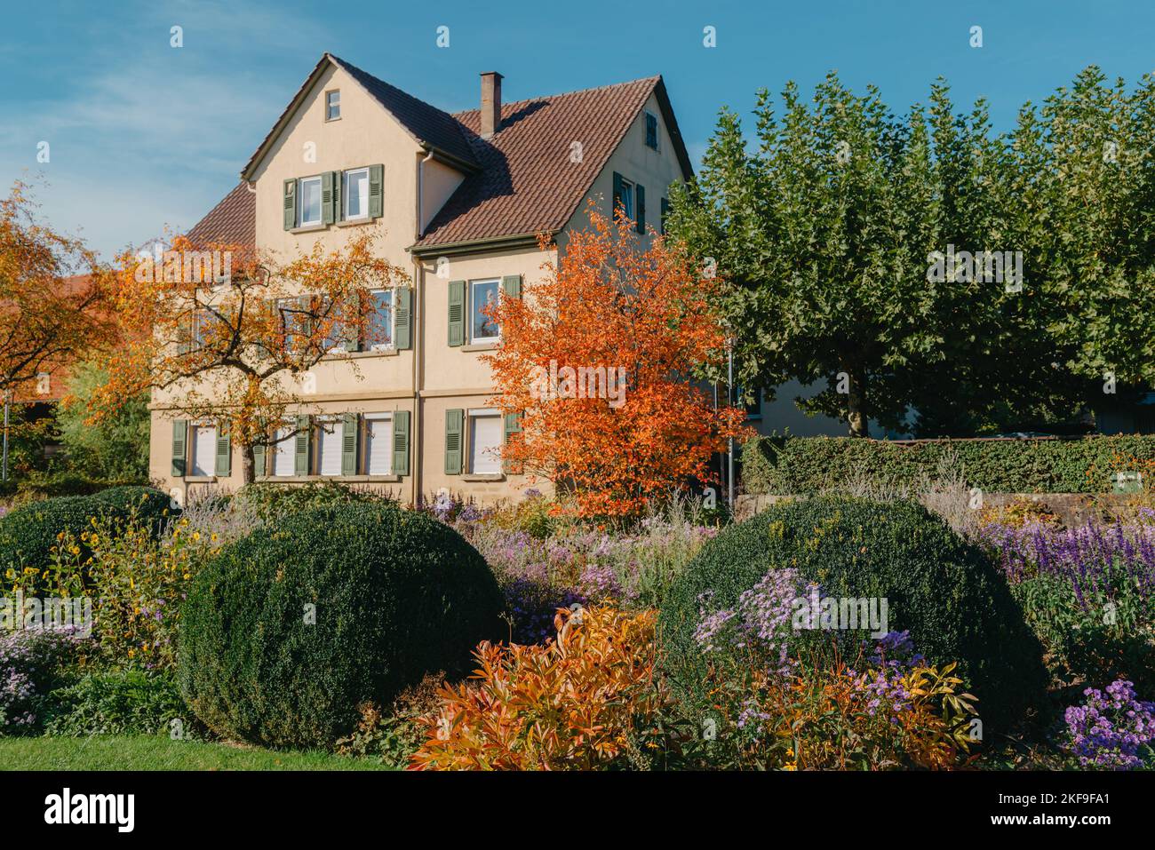 Casa con bel giardino in autunno. Fiori nel parco cittadino di Bietigheim-Bissingen, Baden-Wuerttemberg, Germania, Europa. Autunno Parco e casa, nessuno Foto Stock