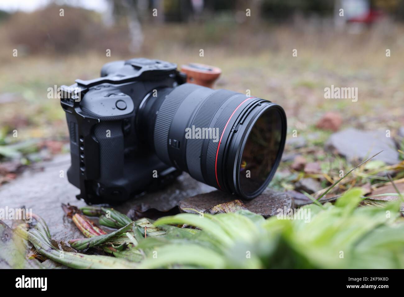 Fotocamera fotografica con obiettivo zoom sul terreno in natura, Foto Stock