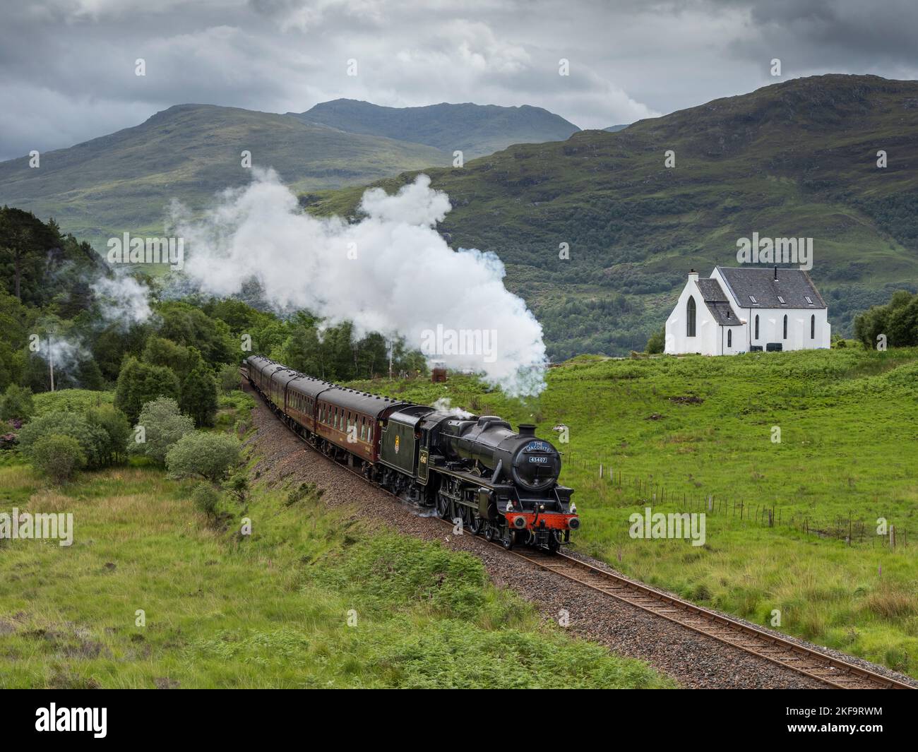 Il treno a vapore Jacobite sulla sua strada per Mallaig come passa l'ex chiesa vicino Polnish. Il treno a vapore è stato usato nelle pellicole di Harry Potter e nel Foto Stock