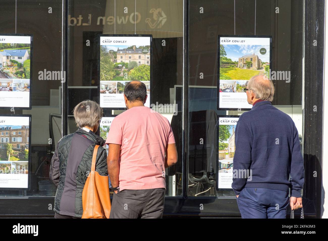 Persone che guardano nella finestra di un ufficio di agenti immobiliari a Bath, Somerset, Inghilterra, Regno Unito Foto Stock