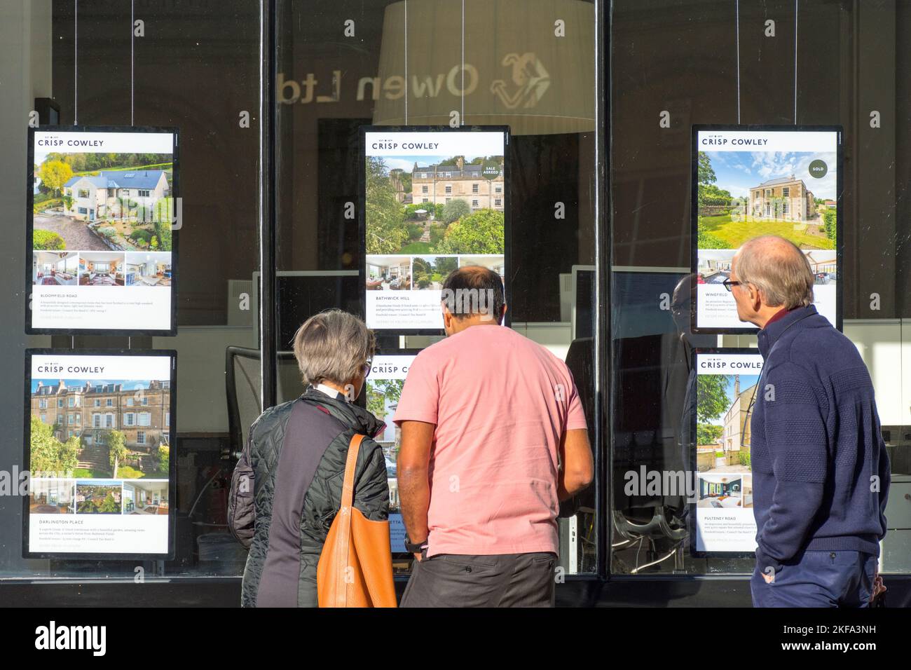 Persone che guardano nella finestra di un ufficio di agenti immobiliari a Bath, Somerset, Inghilterra, Regno Unito Foto Stock