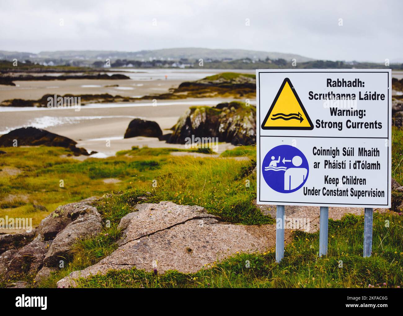 Gaelico e inglese avvertono di forti correnti e di tenere sotto controllo i bambini, County Donegal, Irlanda Foto Stock