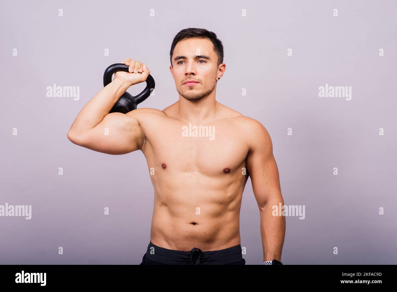 Bell'uomo muscoloso che tiene la campana del bollitore con spazio per le copie. Atleta maschile ispanico Foto Stock