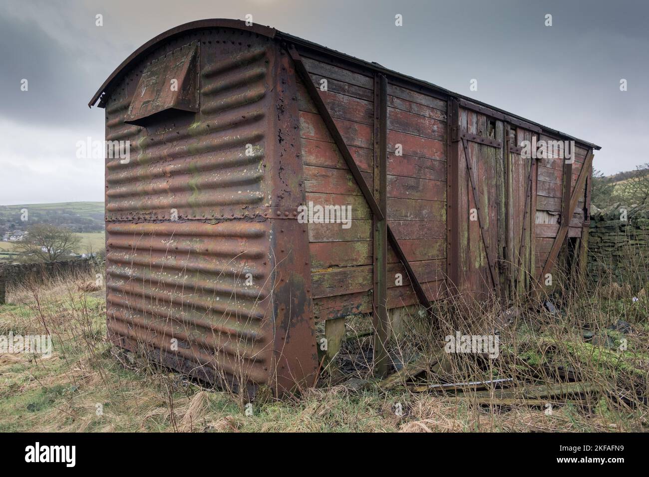 Vecchia carrozza ferroviaria abbandonata sulla brughiera. Rosso rustico metallo e pannelli di legno. Foto Stock