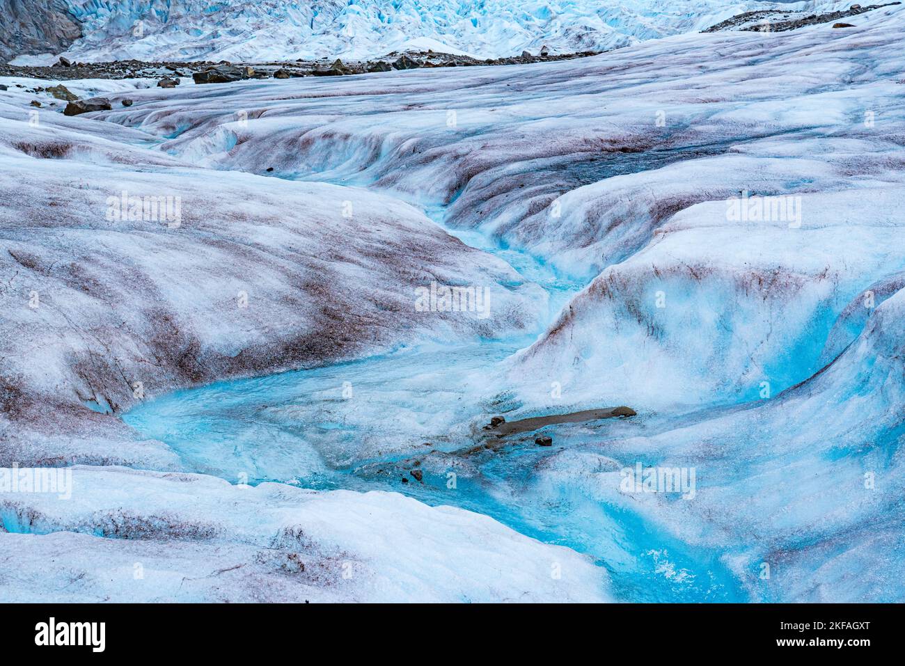 Il ghiaccio fondente del ghiacciaio Mendenhall in Alaska forma un flusso tortuoso di acque cristalline e blu Foto Stock